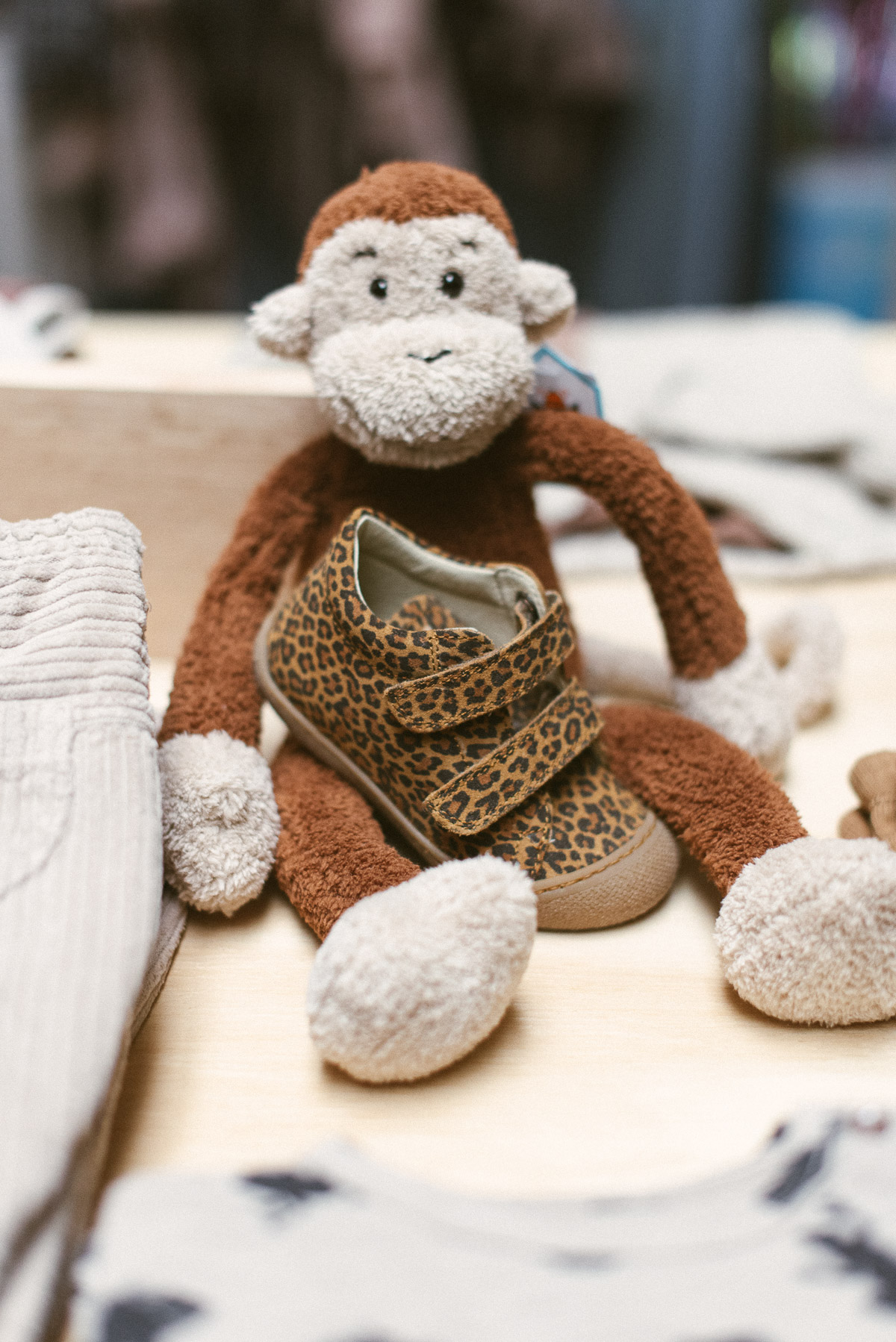 Kuscheltier Affe mit Babyschuh im Leopardenmuster